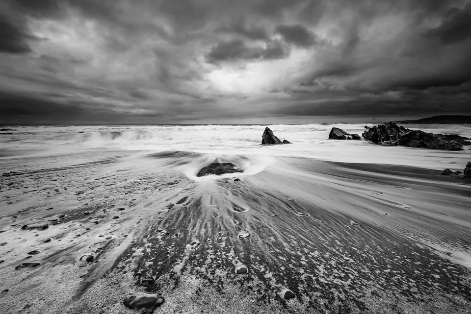 A long exposure photograph of waves moving across a rocky coast